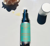 Face Oil Bottle showing oil, rose and bottle cap.