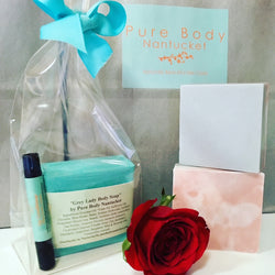 Bar of Soap with Lip Conditioner in Compostable Gift Bag and Ribbon. Also shown are bars of soap, rose and Pure Body Nantucket gift bag with logo.